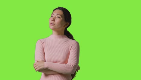 Studio-Shot-Of-Woman-With-Serious-Expression-Looking-All-Around-Frame-Against-Green-Screen-In-VR-Environment